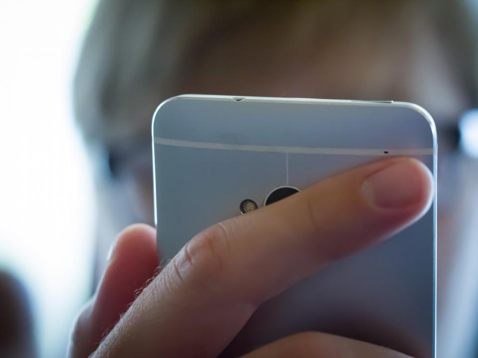 Candidature sur smartphone Main tenant un smartphone devant le visage d'une personne qui consulte l'écran