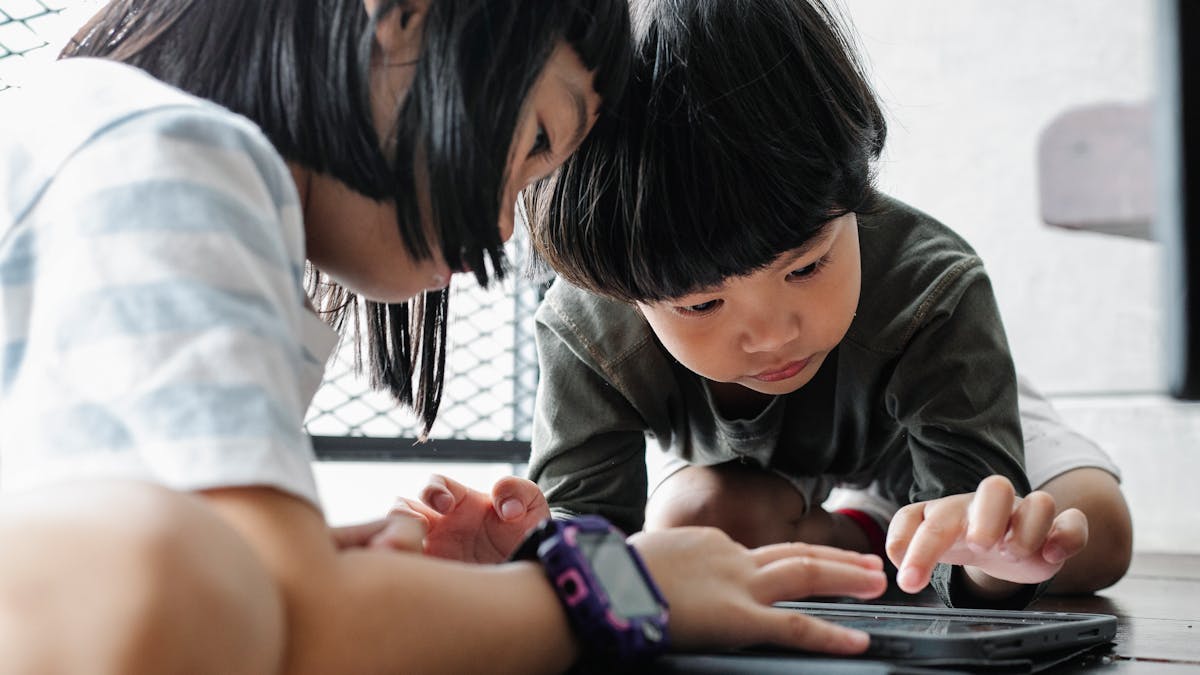 Deux enfants de la génération Alpha utilisent une tablette tactile