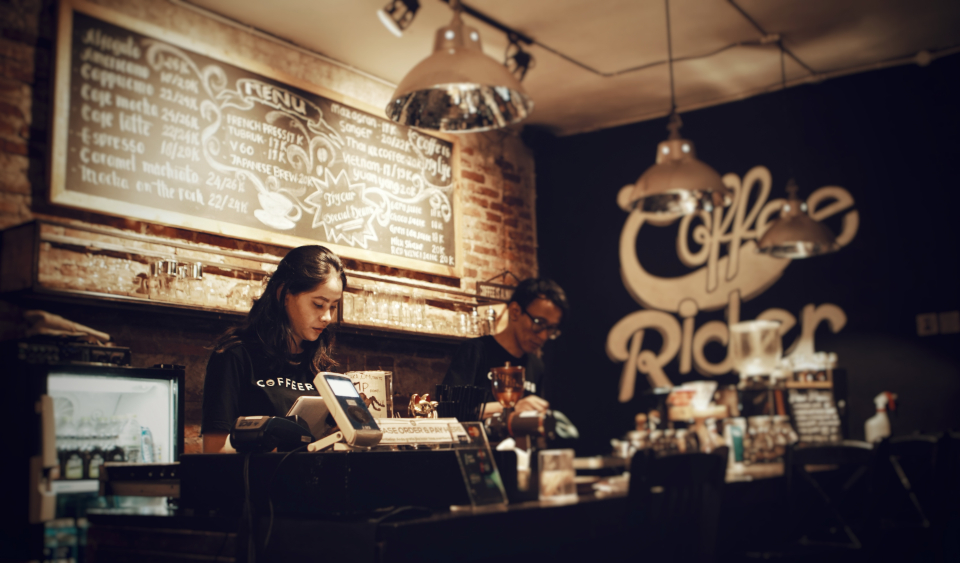 Gestion du temps de travail dans un café Deux employés derrière le comptoir d'un café, l'une à la caisse