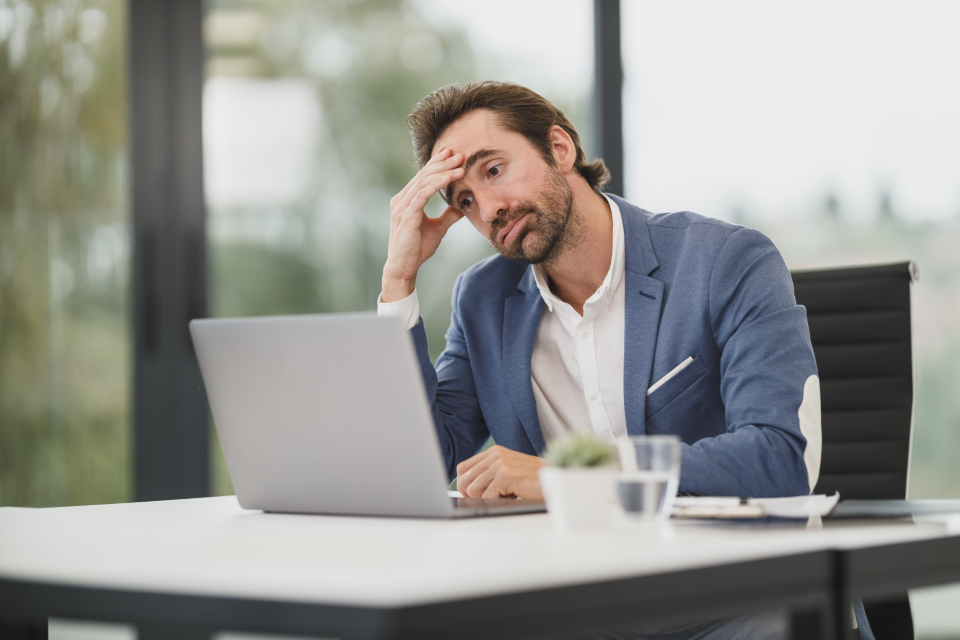 Personne au bureau devant un ordinateur portable avec des documents